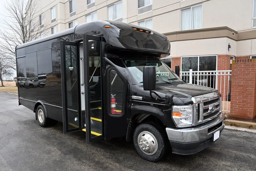 Black Ford E450 minibus owned by Umbrella Global Bus staged at a hotel entrance